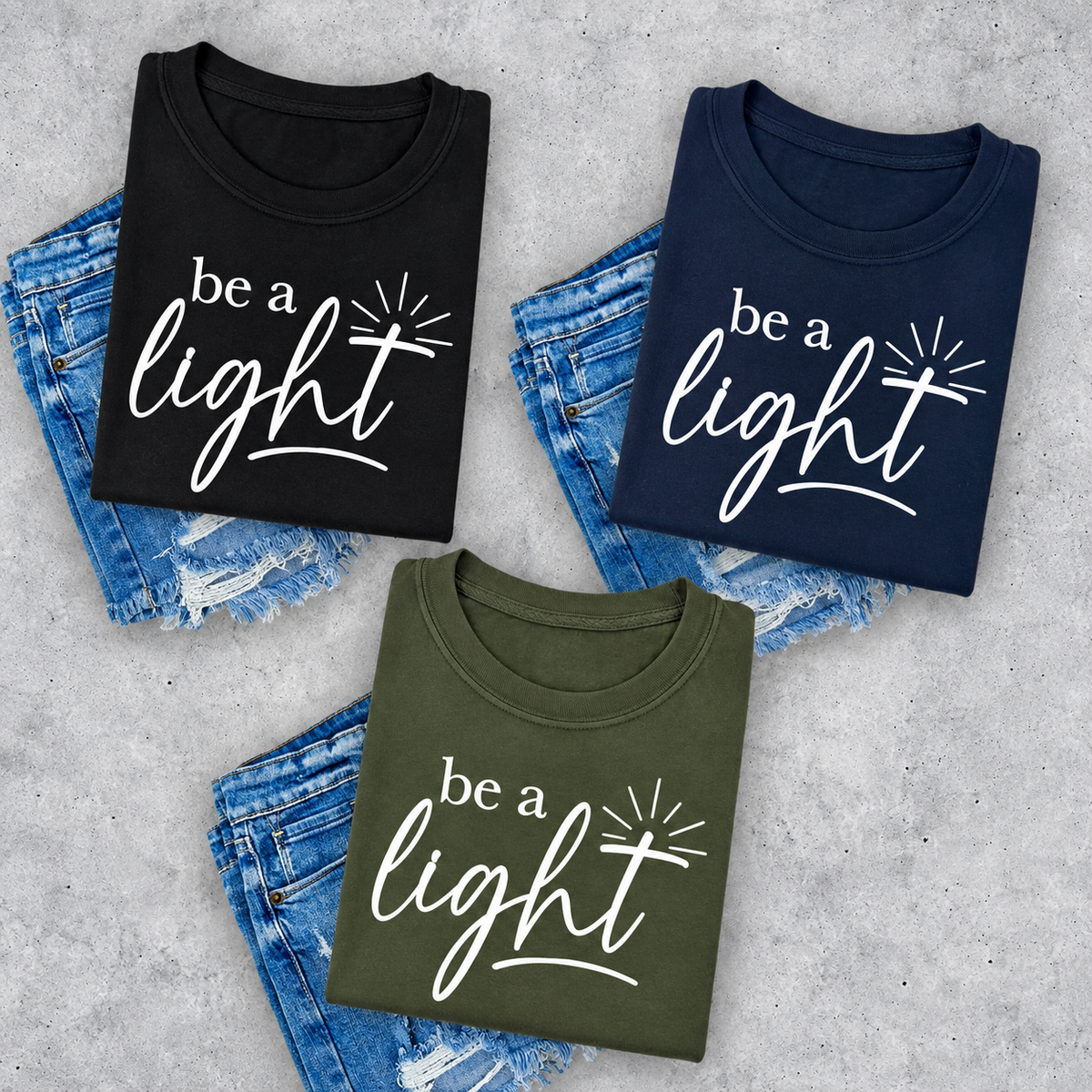Be A Light logo fundraiser tee in black, navy, and military green